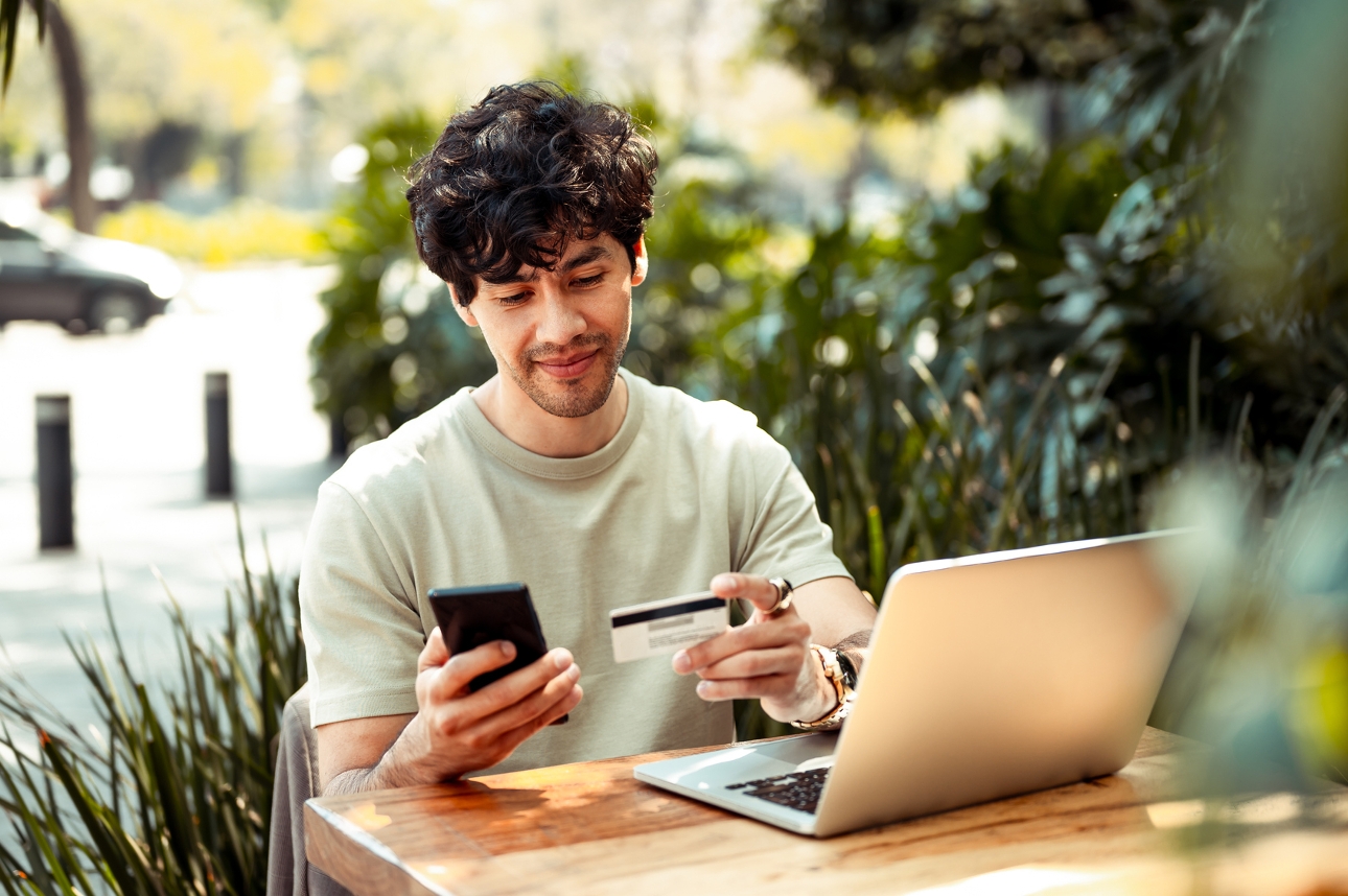 man sat at table with laptop and credit card out