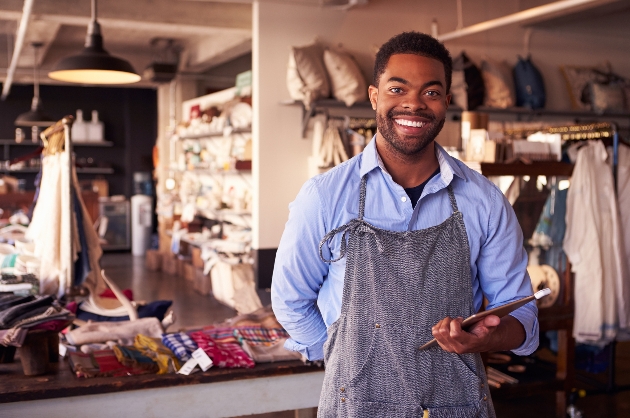 man standing in his shop smiling ready to help