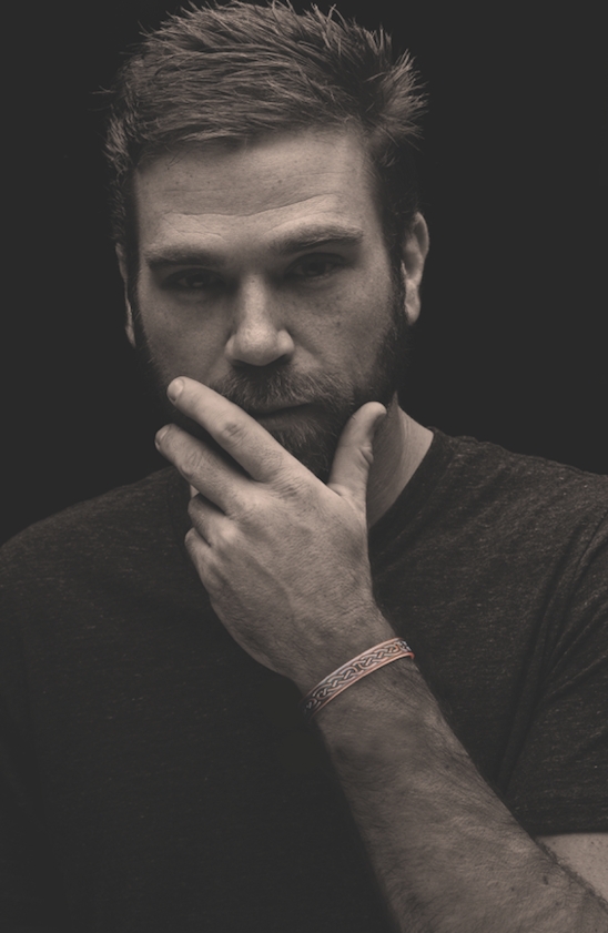 black and white image of a man holding his chin wearing a copper bracelet