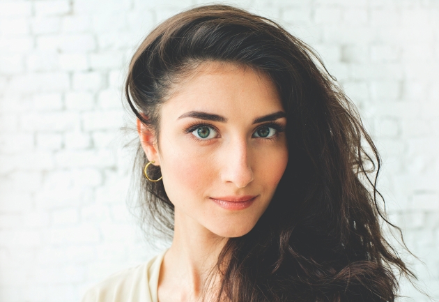 brunette woman with her hair to one side revealing a gold hoop earring 