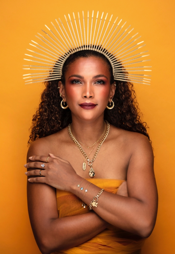 model in orange dress with golden headdress and gold jewellery