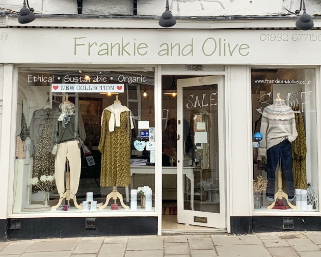 shop front cream facade with olive writing open windows to see inside