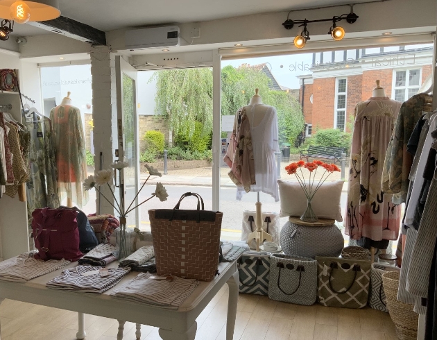 inside of shopping looking outwards mannequins with clothes on and accessories on tables