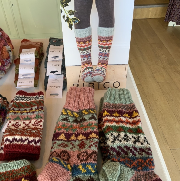 selection of knitted sock on a table in a shop
