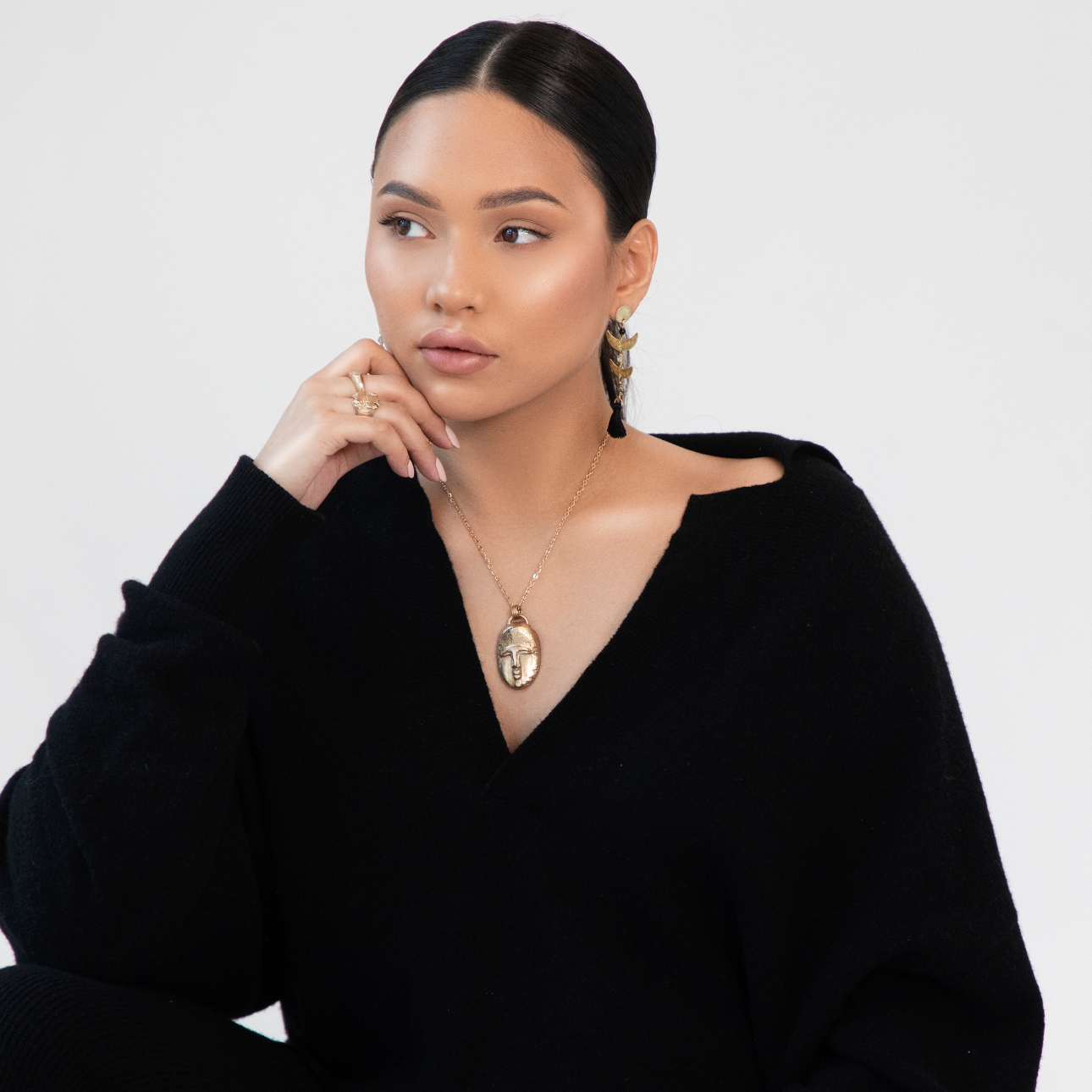 model in black jumper with jewellery 