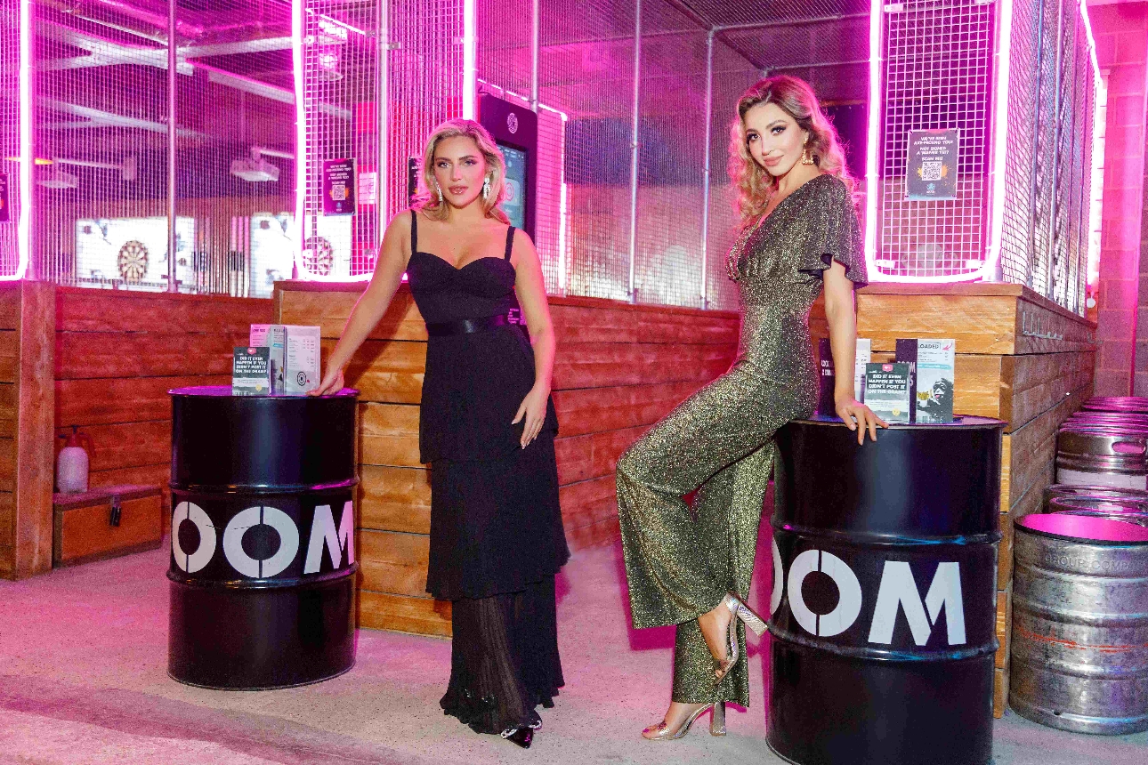 two model in clothes next to oil drums