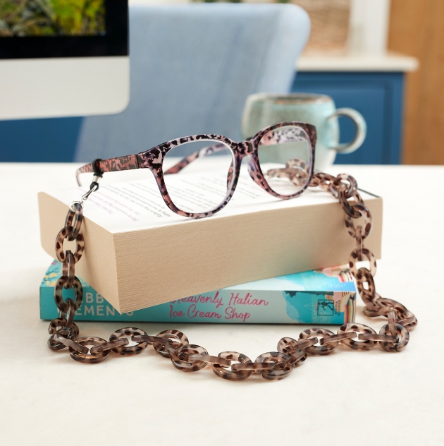 pair of glasses displayed on books with a chunk chain