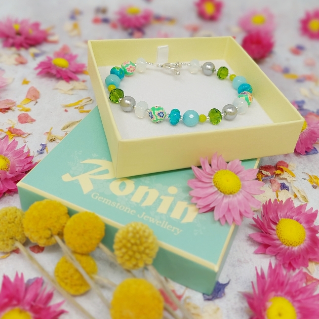 blue bead and silver bracelet in yellow box