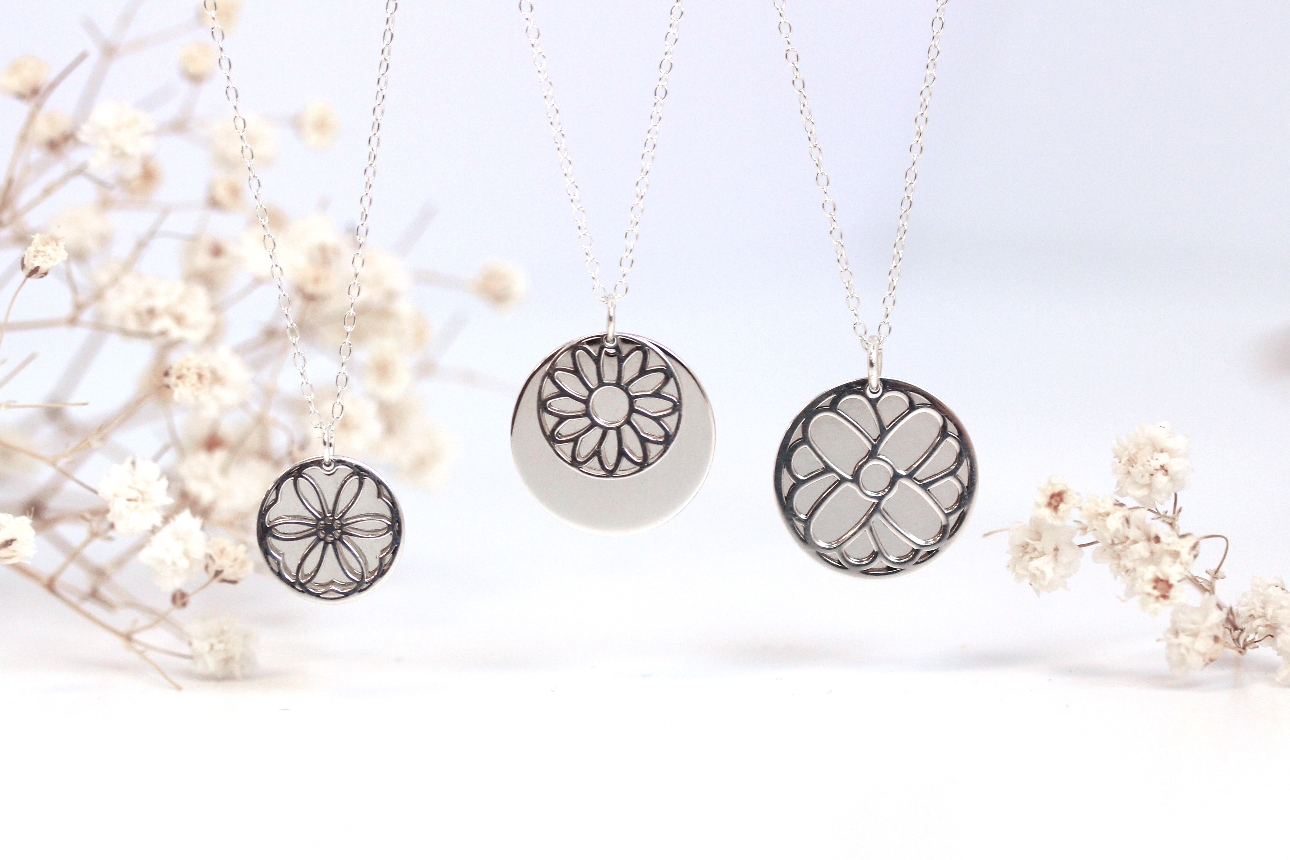 three silver necklaces with circle pendant and flower design