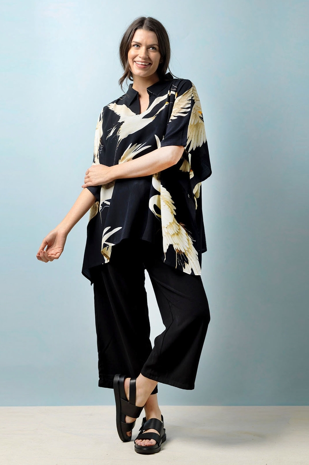 model in wide leg black trouser, kimono top, black sandals