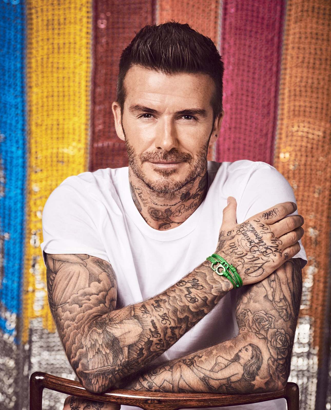 david beckham sat in white tshirt on a wooden chair