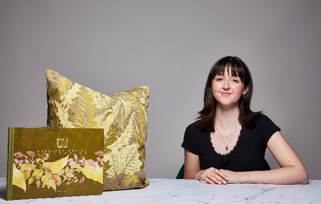 woman in black top with gold cushions on table 