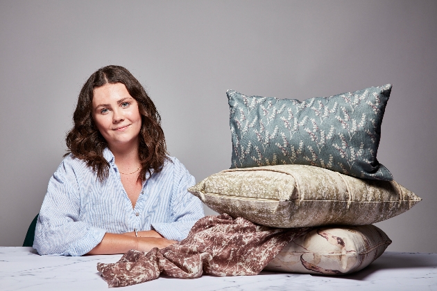 woman in blue shirt at table with pillows in front of her 