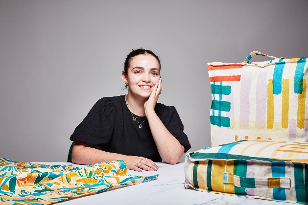 woman in black top with fabric cushions pads in front of her