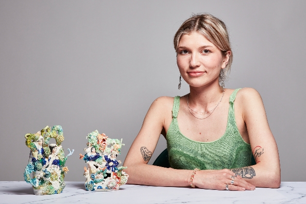 woman in green top with two figurines in front of her