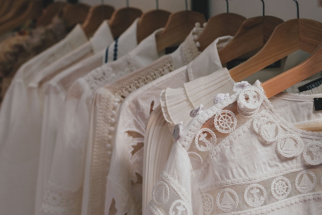 white clothes on wooden hangers on a rail