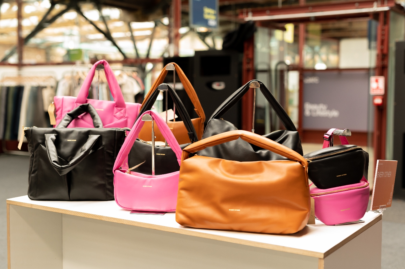 different coloured leather bags on an exhibition stand