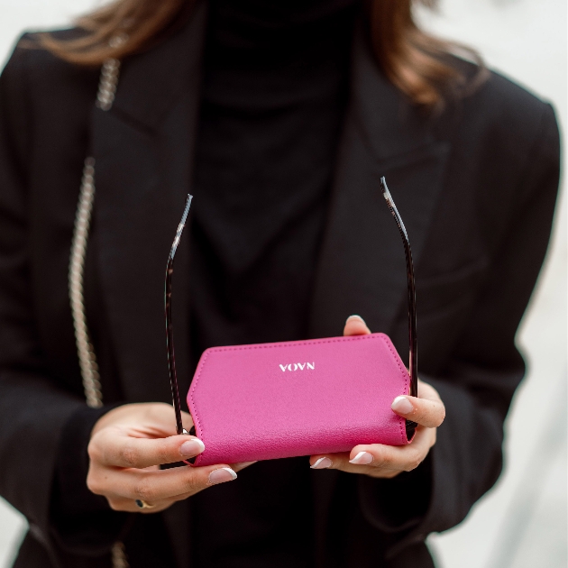 woman in black holding pink glasses case