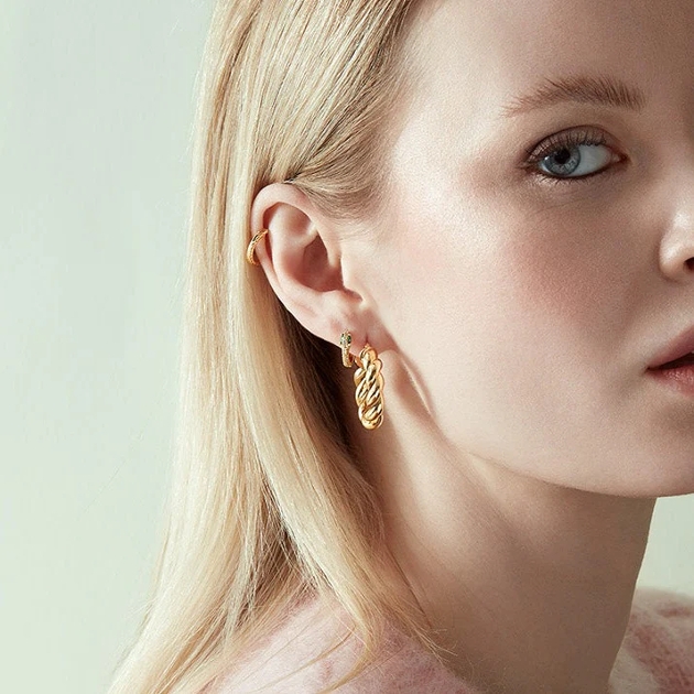 model wearing three hoop earrings in gold