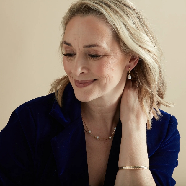 model wearing gold hoop earring with a pearl drop