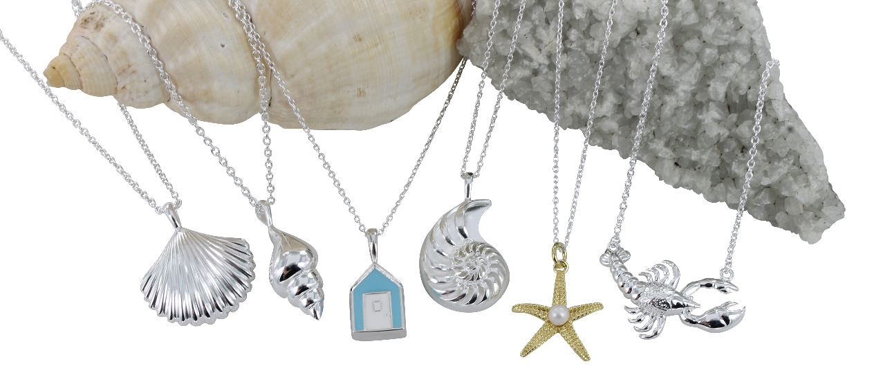 row of sea themed necklaces displayed on shells
