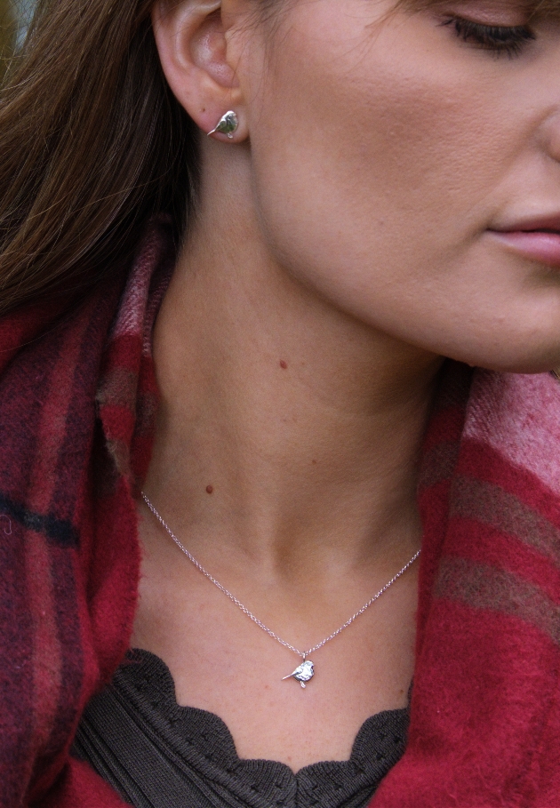 silver bird earring and chain on woman