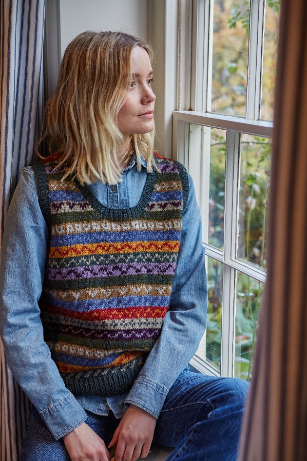 woman looking out window in knitted vest
