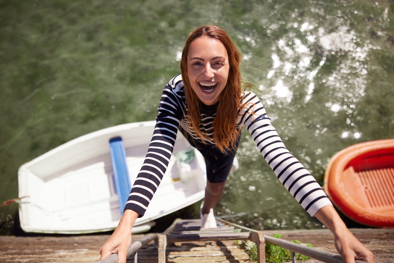 woman climbing up a ladder out of the water