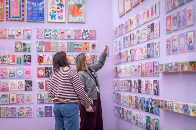 visitors looking at cards at a trade show